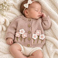 Newborn pink floral knit cardigan on sleeping baby, button front and flower applique