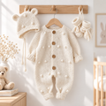White hand-knitted newborn romper with button placket, pom-pom knit, plus bonnet and booties