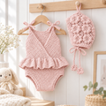Pink knitted newborn romper with ruffled hem and matching bonnet