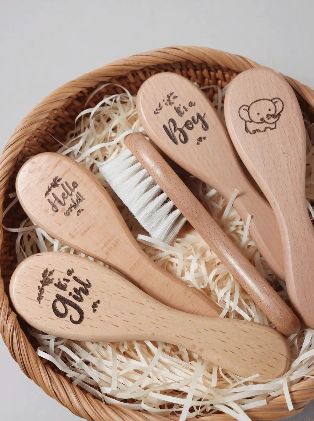 Beechwood baby hair brush set with soft white bristles in a wicker gift basket
