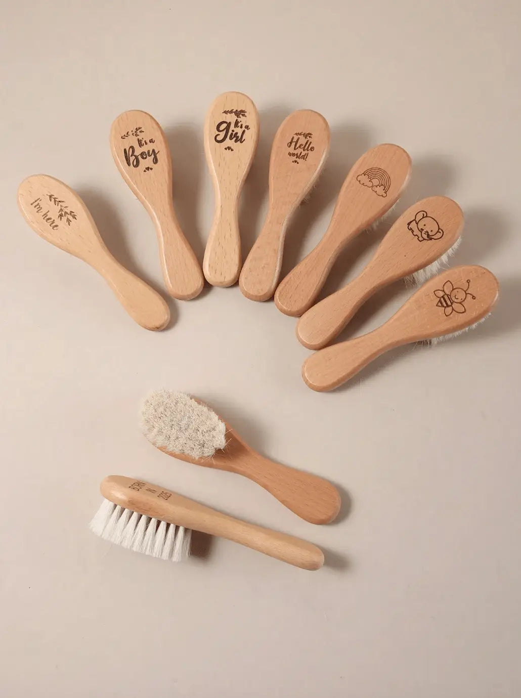 Beechwood newborn hair brushes with soft bristles, plus small cleaning brush, flat lay