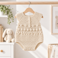 Cream crochet newborn girl romper with scalloped yoke and button-front, textured knit