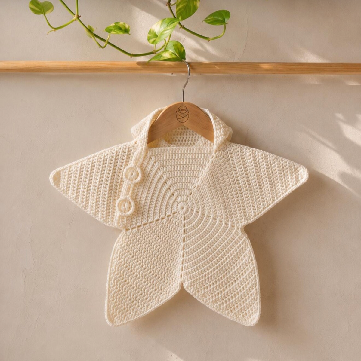 Cream crochet baby star poncho with hood, button detail and spiral pattern
