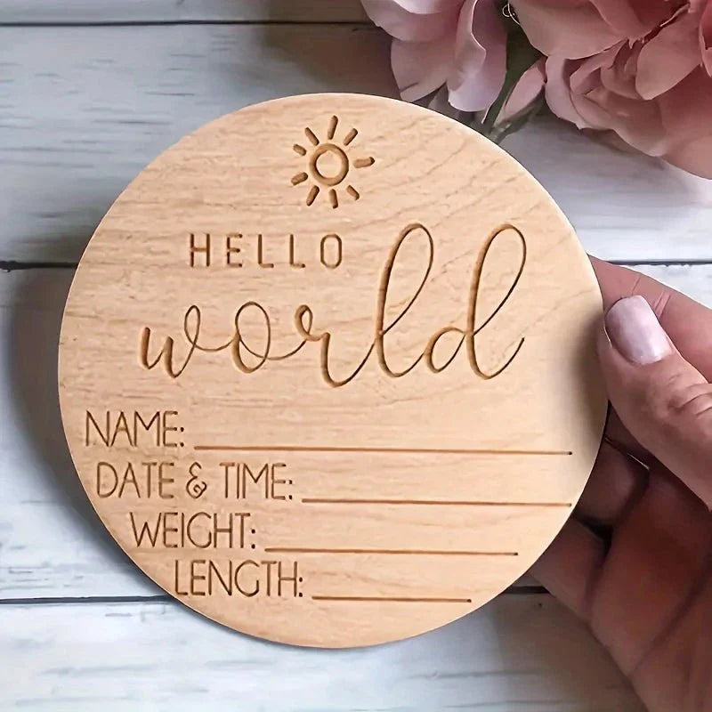 Round wooden baby photo card engraved 'Hello World' with sun icon and blank fields
