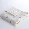 White muslin baby blanket, folded with repeating teddy animal print and soft gauze texture